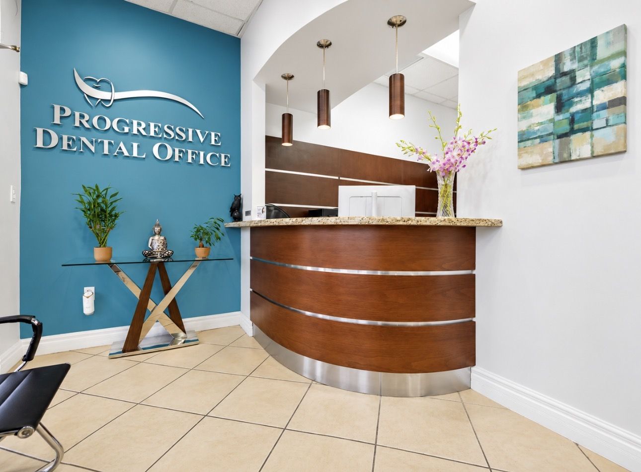 The reception area with the teal Progressive Dental Office logo wall